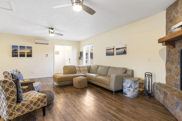 living room featuring dark hardwood / wood-style floors, a wall unit AC, ceiling fan, and a stone fireplace