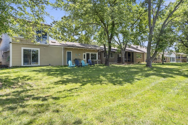 rear view of property featuring a lawn