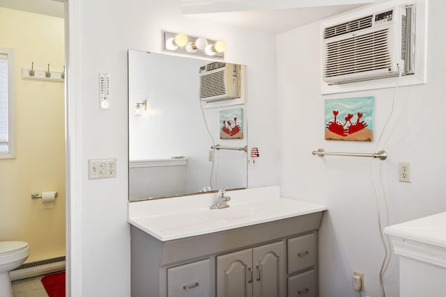 bathroom with vanity, toilet, baseboard heating, and a wall mounted AC