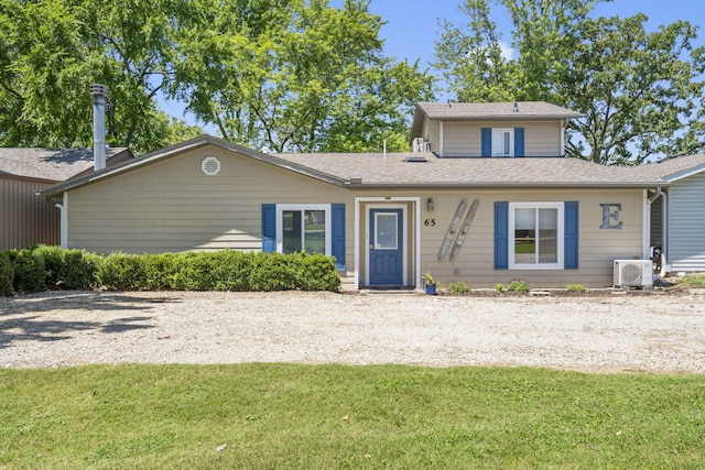 view of front of property with a front yard and ac unit