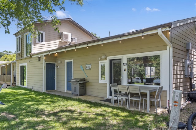 back of property featuring a patio and a lawn