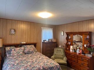 bedroom featuring wood walls