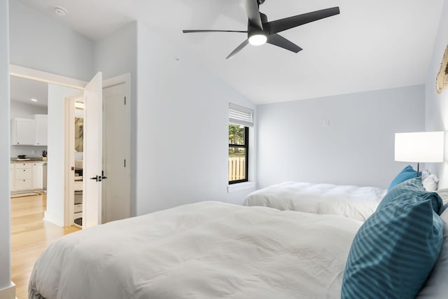 bedroom featuring a ceiling fan, vaulted ceiling, and light wood-style flooring