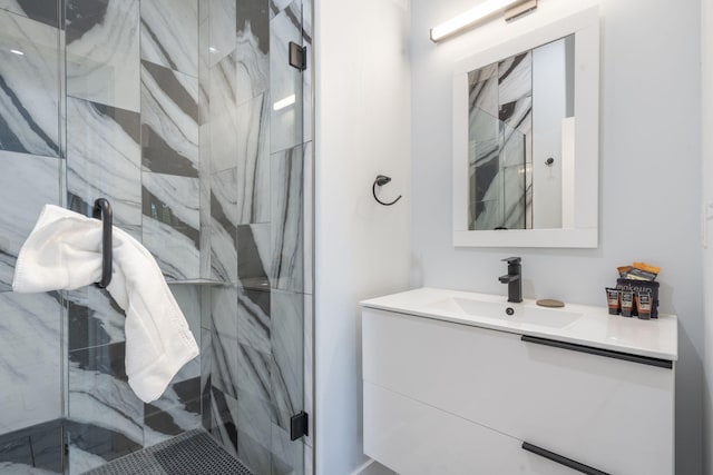 bathroom with a marble finish shower and vanity