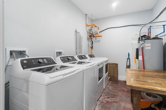 washroom with water heater, laundry area, and separate washer and dryer
