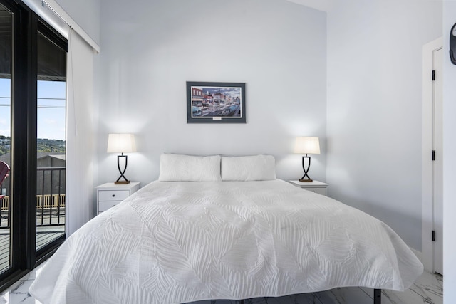 bedroom with marble finish floor and access to exterior