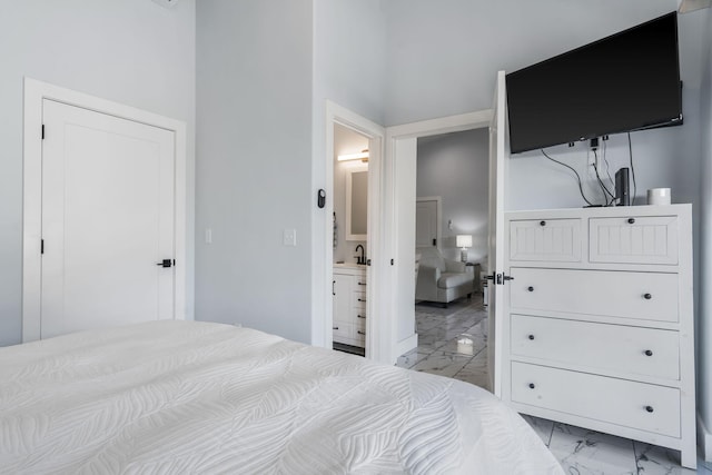 bedroom featuring ensuite bathroom and marble finish floor