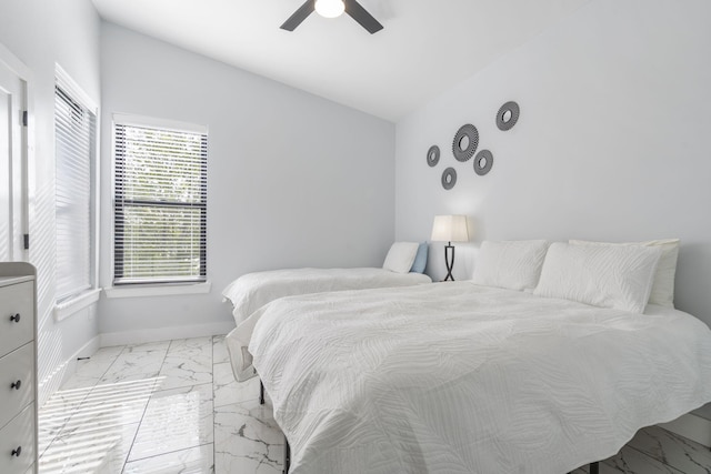 bedroom featuring vaulted ceiling, marble finish floor, a ceiling fan, and baseboards