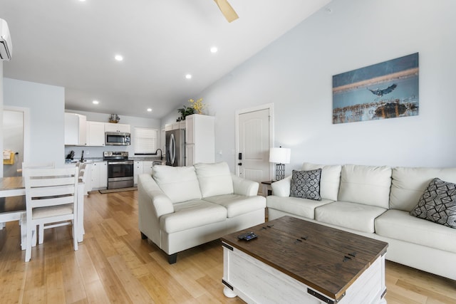living area featuring light wood-style floors, recessed lighting, a wall mounted air conditioner, and high vaulted ceiling