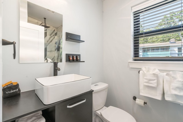 full bath featuring visible vents, vanity, toilet, and a walk in shower