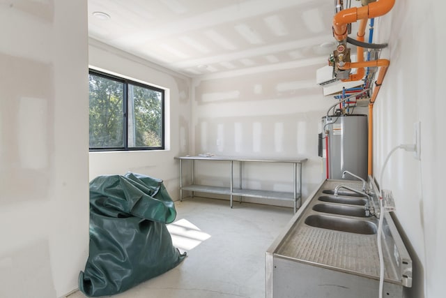 kitchen featuring a sink, concrete floors, and gas water heater