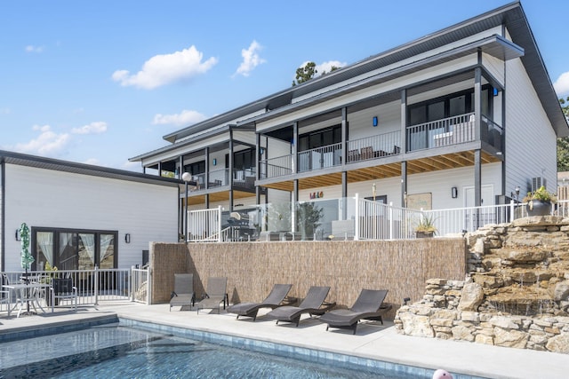 rear view of house with a patio area, fence, and a fenced in pool