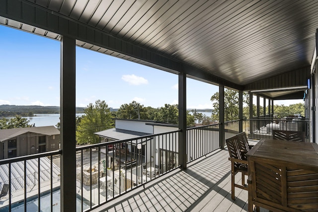 wooden terrace with outdoor dining space and a water view