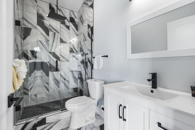 bathroom featuring toilet, marble finish floor, a marble finish shower, and vanity