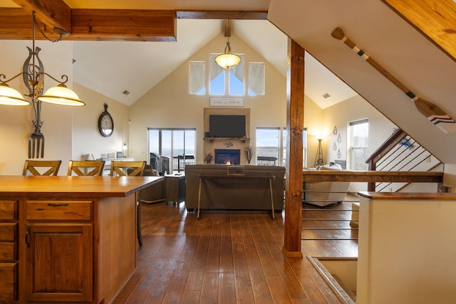 kitchen with high vaulted ceiling, an inviting chandelier, dark hardwood / wood-style floors, beamed ceiling, and decorative light fixtures