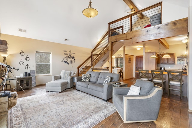 living room with beamed ceiling, a high ceiling, and dark hardwood / wood-style flooring