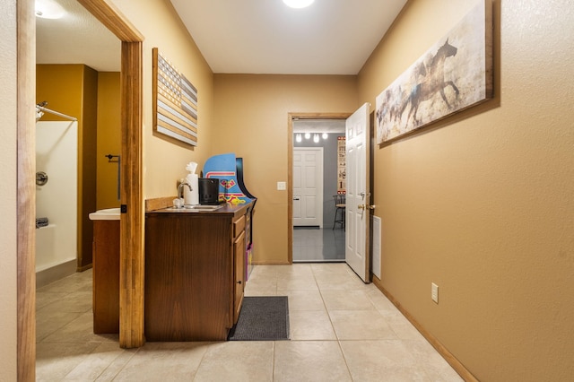 hall with light tile patterned floors and sink