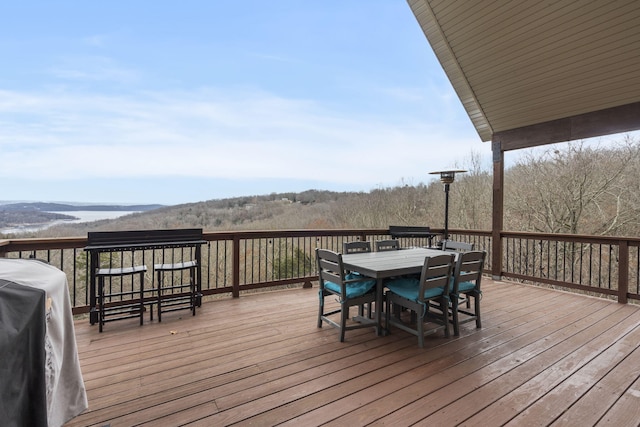 wooden terrace featuring grilling area and a water view