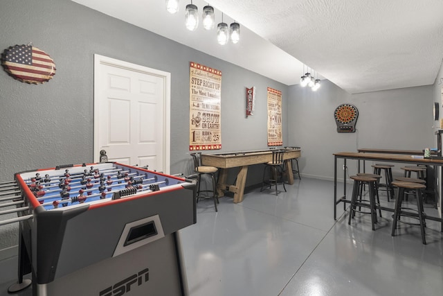 playroom with bar area, concrete floors, and a textured ceiling