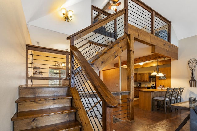 stairway with high vaulted ceiling and wood-type flooring