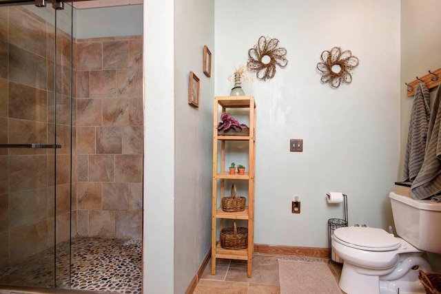 bathroom featuring toilet and a shower with shower door