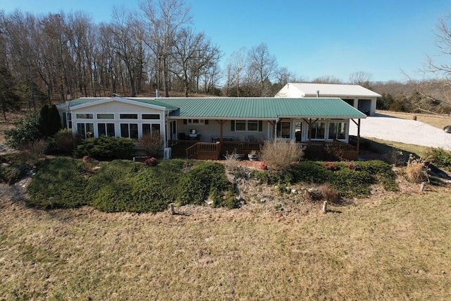 rear view of house featuring a garage, covered porch, and a lawn