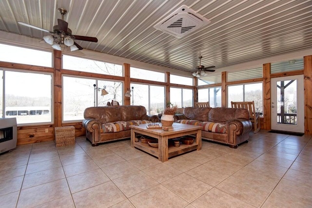 tiled living room with a healthy amount of sunlight, heating unit, and ceiling fan