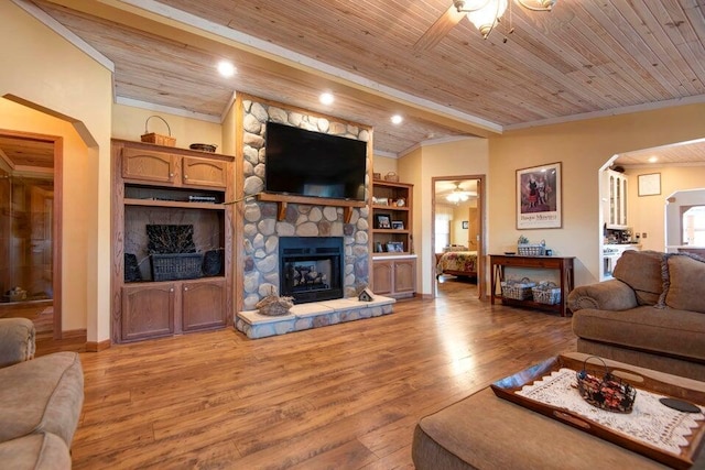 living room featuring a fireplace, wood ceiling, light hardwood / wood-style flooring, and ceiling fan