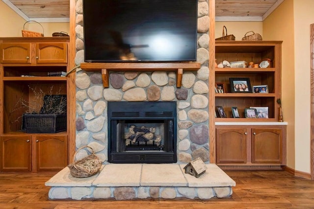 room details with crown molding, wooden ceiling, a fireplace, and light hardwood / wood-style floors