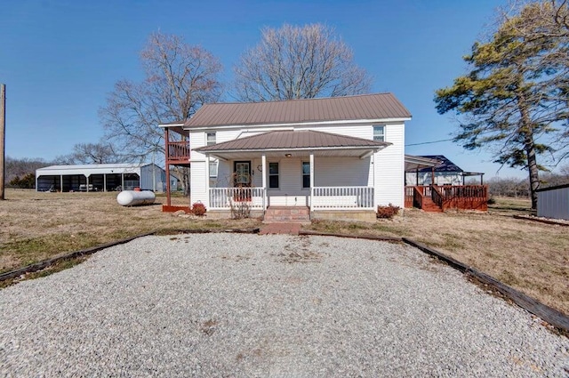 view of front of home featuring a carport, a porch, and a front yard