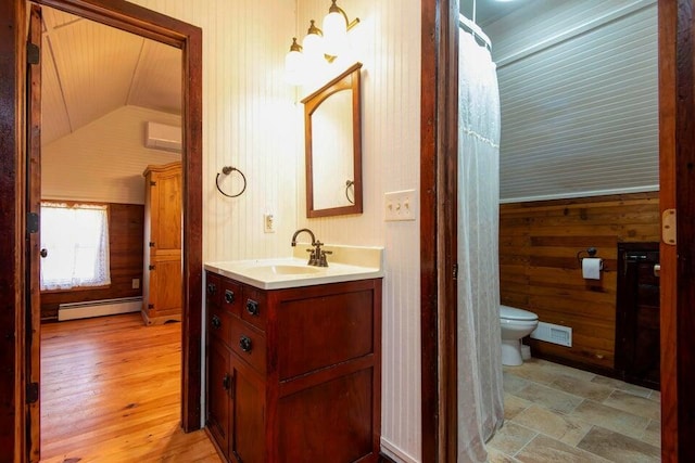 bathroom with vaulted ceiling, wooden walls, vanity, a baseboard heating unit, and toilet