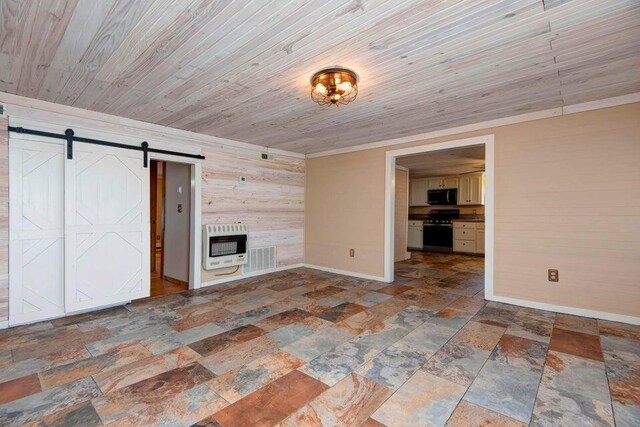 unfurnished living room with wood ceiling, a barn door, heating unit, and wood walls