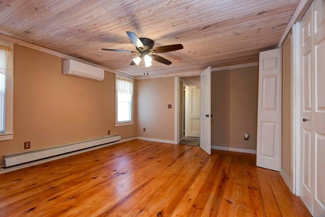 unfurnished bedroom with a baseboard heating unit, a wall mounted AC, wood ceiling, and light hardwood / wood-style flooring