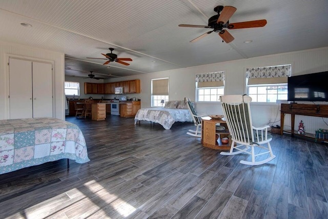 bedroom featuring dark hardwood / wood-style flooring, multiple windows, and ceiling fan