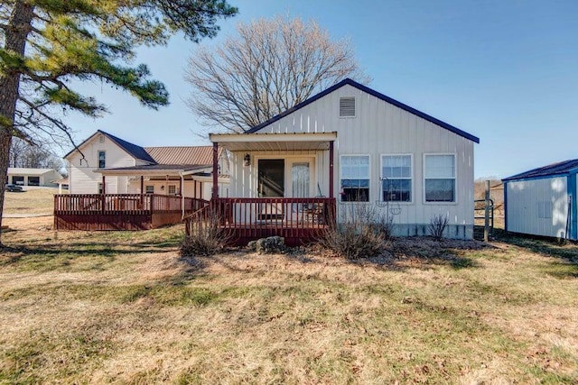 rear view of property with a lawn and a deck