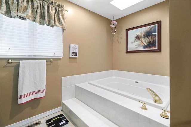 bathroom with tile patterned floors and tiled bath