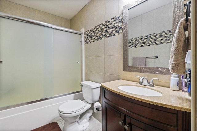 full bathroom with tile patterned floors, vanity, tile walls, enclosed tub / shower combo, and toilet