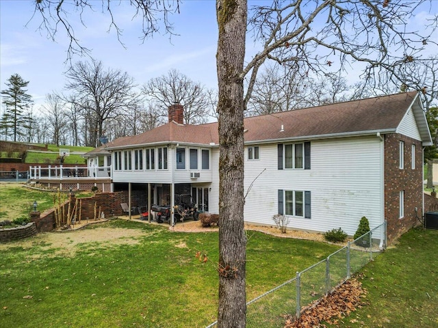 back of property featuring a wooden deck, central AC, a patio area, a sunroom, and a yard