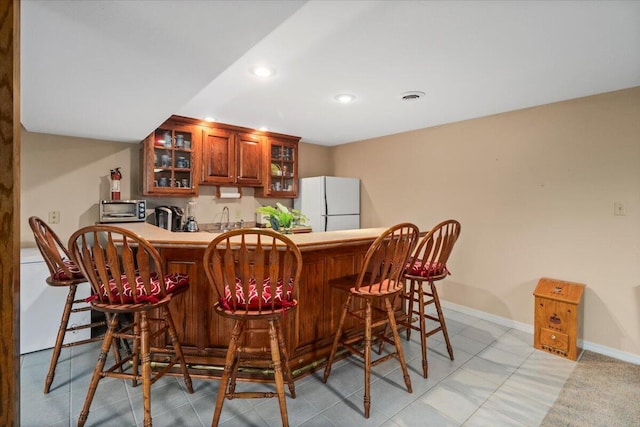 bar featuring white fridge and sink