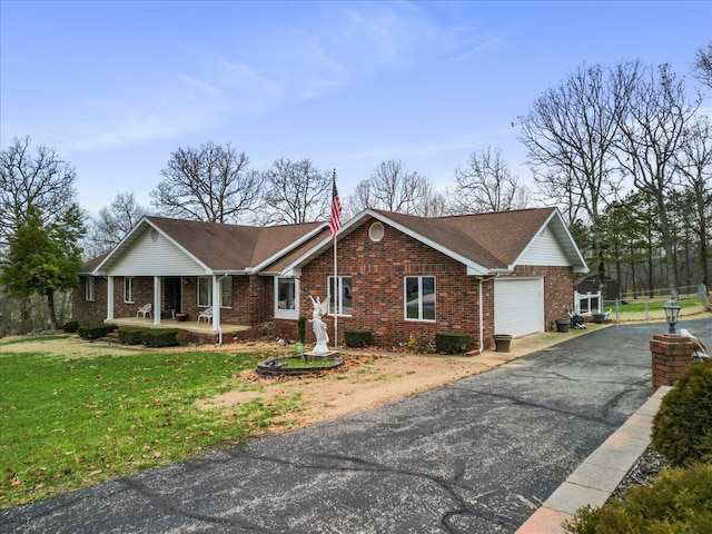 single story home featuring a front lawn, a porch, and a garage