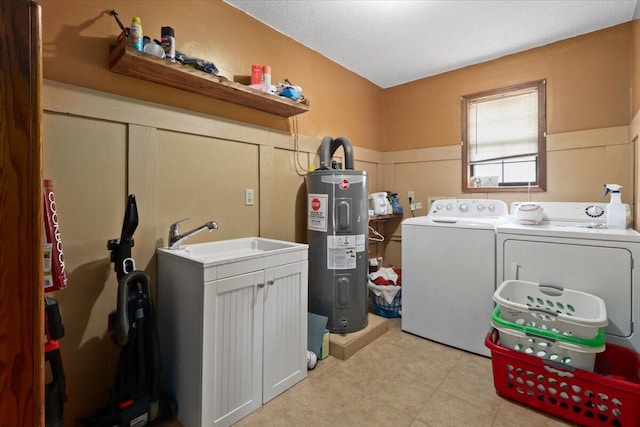 laundry area featuring washing machine and clothes dryer, electric water heater, and sink