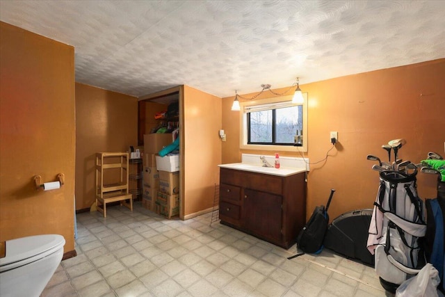 bathroom featuring a textured ceiling, vanity, and toilet