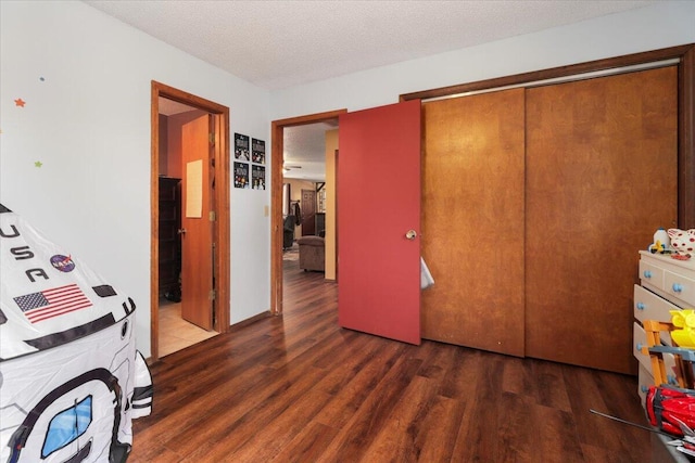 interior space featuring a textured ceiling, dark wood-type flooring, and a closet