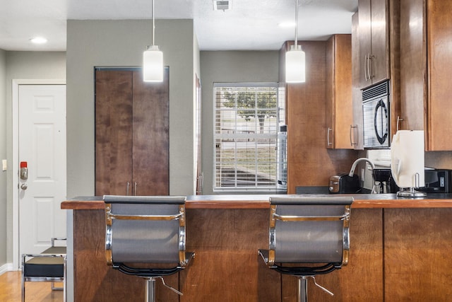 kitchen with a kitchen breakfast bar and decorative light fixtures