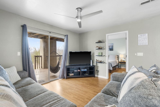 living room featuring ceiling fan and hardwood / wood-style floors