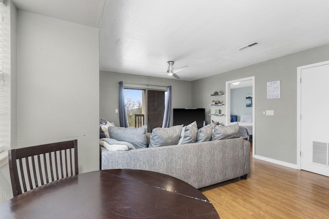 living room with a textured ceiling, hardwood / wood-style flooring, and ceiling fan