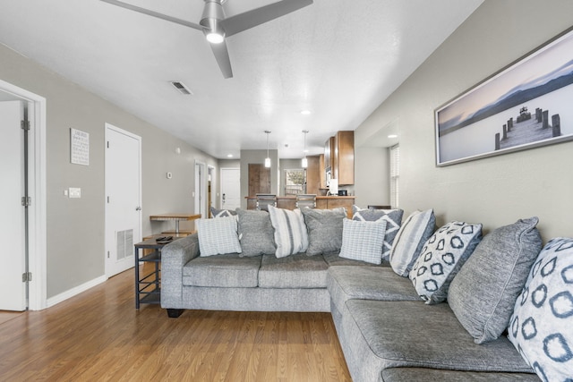 living room with ceiling fan and hardwood / wood-style flooring