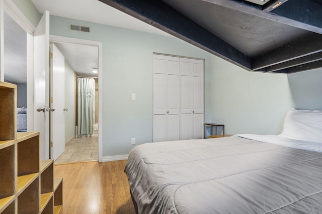 bedroom with light hardwood / wood-style floors and a closet