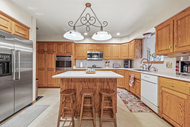 kitchen featuring pendant lighting, sink, a breakfast bar area, a kitchen island, and stainless steel appliances