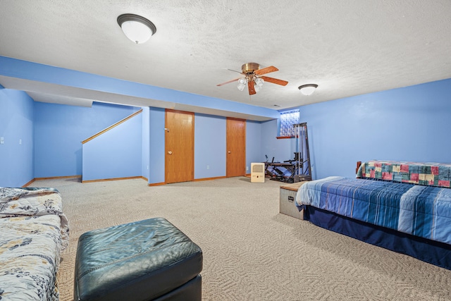 carpeted bedroom featuring ceiling fan and a textured ceiling